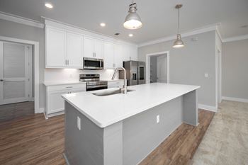 a large kitchen with white cabinets and a white counter top